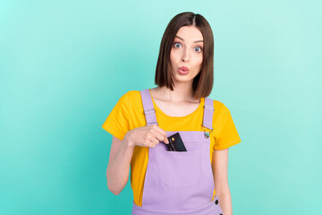 Photo of young amazed shocked woman hold hands credit card sale put pocket isolated on teal color background