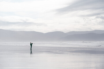 Fototapeta na wymiar Man taking pictures on Beach in Dingle Peninsula, Ireland