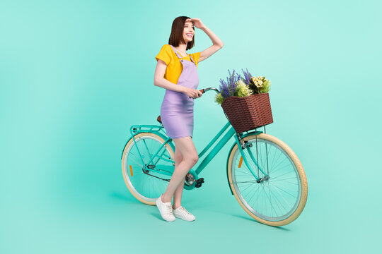 Full length photo of young happy woman look forward hand head biker free time isolated on teal color background