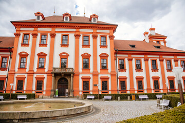 Prague, Czech Republic, 25 April 2021: Troja castle, Historical chateau and red and white baroque palace surrounded by a garden at spring day, staircase decorated with stone sculptures