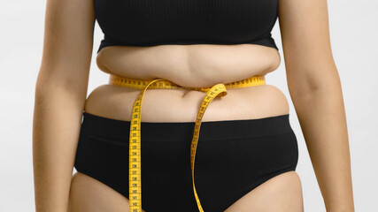 Excess weight caucasian woman with measuring sentimeter tape hate her body. Beauty standards....