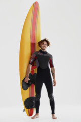 Young european curly surfer stand near surfboard