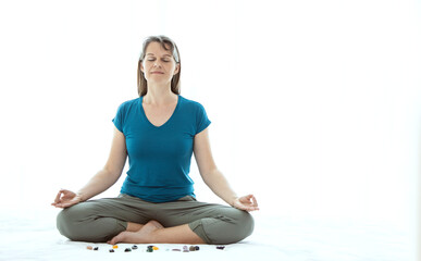 Middle aged woman meditating with crystals