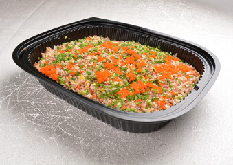stir fried healthy brown rice with mixed vegetables and fish roe in black party bento tray box for asian take away halal menu