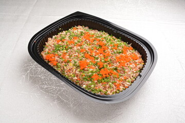 stir fried healthy brown rice with mixed vegetables and fish roe in black party bento tray box for asian take away halal menu