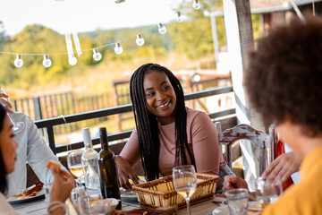 Group of friends at reunion eating and drinking wine.
