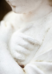 Hands on the chest. Old sculpture.