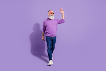 Full length body size view of attractive cheerful confident grey-haired man walking waving hi isolated over purple violet color background