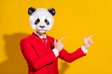 Photo of reliable guy direct finger empty space wear panda head red suit tie isolated on yellow...