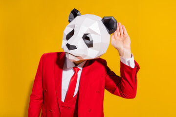 Photo of curious guy eavesdropping empty space wear panda mask red tux isolated on yellow color...