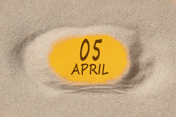 April 5. 5th day of the month, calendar date. Hole in sand. Yellow background is visible through hole. Spring month, day of the year concept