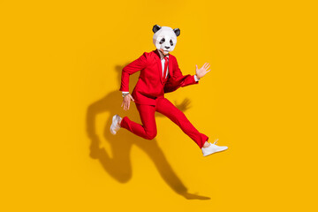 Photo of sporty energetic panda guy jump run wear mask red tux shoes isolated on yellow color background