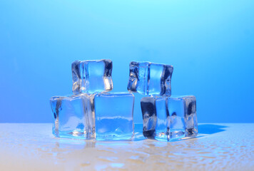 Photo of 5 wet artificial or fake ice cube at Blue Gradient background