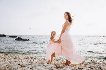 Fototapeta na wymiar Mother and Daughter in pink dresses. Family.