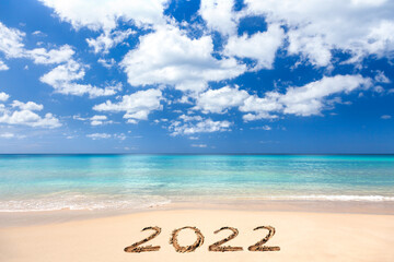 Fototapeta na wymiar 2022 written on sandy beach