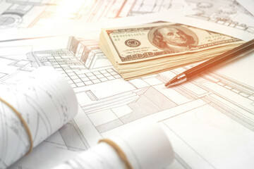 Working on construction project background. Office table with dollars and pen on sketches