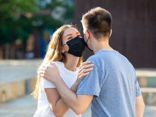 Welcome kiss in protective masks of boy and a girl