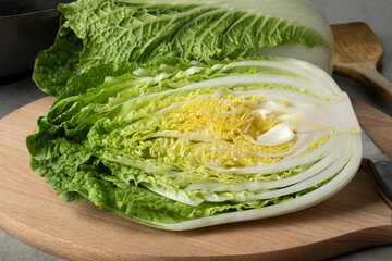 Whole and half fresh raw Chinese cabbage close up on a cutting board 