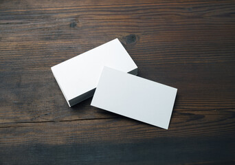 Blank business cards on wood table background. Mockup for branding identity. Template for graphic...