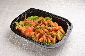 stir fried big tiger prawn with pumpkin creamy sauce and curry leaf in black party bento tray box for asian take away halal menu