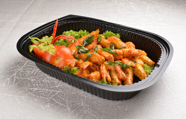 stir fried big tiger prawn with pumpkin creamy sauce and curry leaf in black party bento tray box for asian take away halal menu