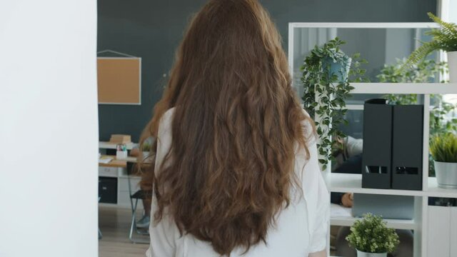 Slow motion of female employee walking inside open space office meeting colleagues holding tablet. Contemporary workplace abd businesspeople concept.