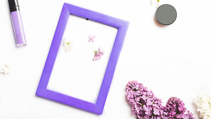 Different makeup cosmetics on white background with space for text with A colored frame decorated with a branch of lilac on a white background.. Flat photo frame and lilac flowers