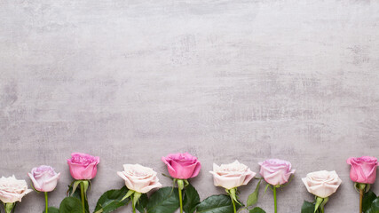 Flowers valentine day composition. Frame made of pink rose on gray background. Flat lay, top view, copy space.