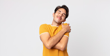 hispanic handsome man feeling in love, smiling, cuddling and hugging self, staying single, being...