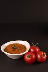 Fresh vegetables and dried veggie powder. Tomato on dark paper background. Vegetarian healthy detox food.
