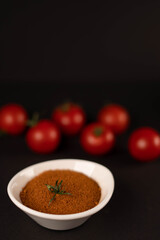 Fresh vegetables and dried veggie powder. Tomato on dark paper background. Vegetarian healthy detox food.
