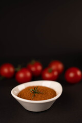 Fresh vegetables and dried veggie powder. Tomato on dark paper background. Vegetarian healthy detox food.