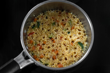 Top view of the healthy homemade dish - bulgur with vegetables in the pot on the stove. Concept of Healthy Food. Healthy diet. Super Food. Vegetarian.