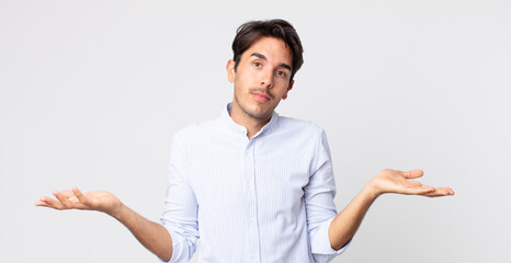 hispanic handsome man feeling puzzled and confused, unsure about the correct answer or decision,...