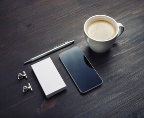Branding identity template. Coffee cup, smartphone, blank business card and pen on wood table background..