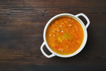 Bowl of soup on wood table background. Flat lay.