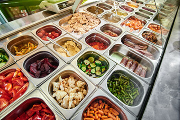 Showcase salad bar with an assortment of ingredients for healthy and dietary food. Salad take away. High quality photo