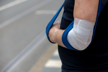 Health care and medical concept, A man wearing hand sling with broken elbow, Operation or surgery...