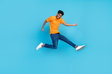 Fototapeta na wymiar Full length photo of happy dark skin cheerful young man jump up winner celebrate isolated on blue color background