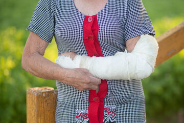 An elderly woman with a broken arm.A cast on a woman's arm.