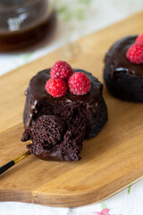 Chocolate muffins with icing bitten off. A piece of chocolate fondant on a spoon. Homemade lava chocolate cake. Cupcake with fondant lava. Eat dessert. Man eating dessert. An abandoned piece of cake.