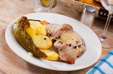 Fried Iberian pig served with potatoes, parsley and stewed pepper