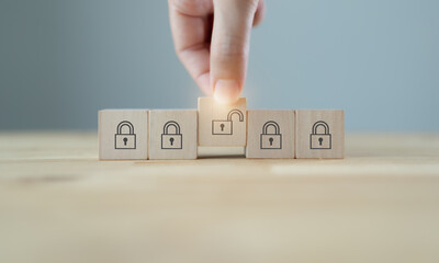 Business planning , strategy and problems solving to find solution..Key unlocking to achieve goals and mission. Man hold wood cubes with unlock key and keys icon on table; grey background. Copy space.