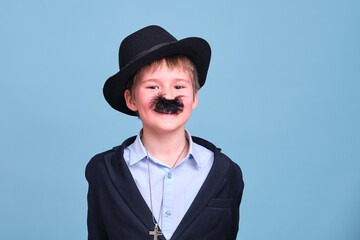 A schoolboy with a hat and a fake mustache on a blue background