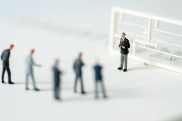 Miniature people A Businessman speech presentation on public stage on white background using as...