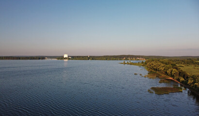 Aerial view of green shore of blue lake on summer morning