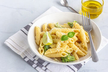Penne Pasta with Broccoli Garnished with Lemon and Basil Close Up Photo