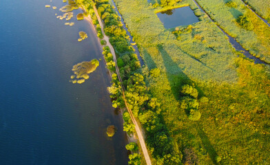 Aerial view of a beautiful green coast with a road near the sea