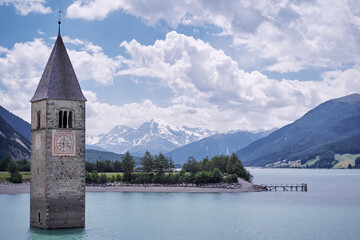 Beautiful view of the lake Resia. Famous tower in the water. Alps, Italy, Europe.