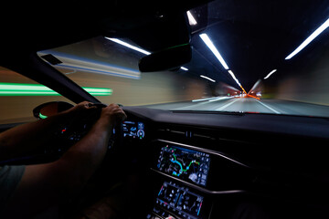 Driving a car in a tunnel viewed from inside the vehicle.